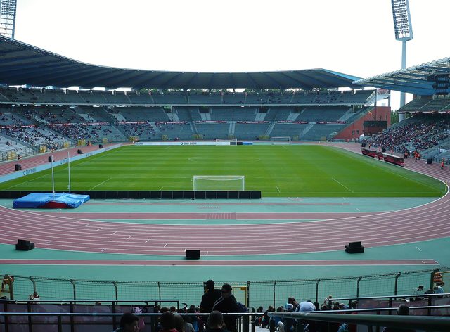 Het lege Koning Boudewijnstadion met een groen voetbalveld, een rode atletiekbaan en tribunes eromheen.