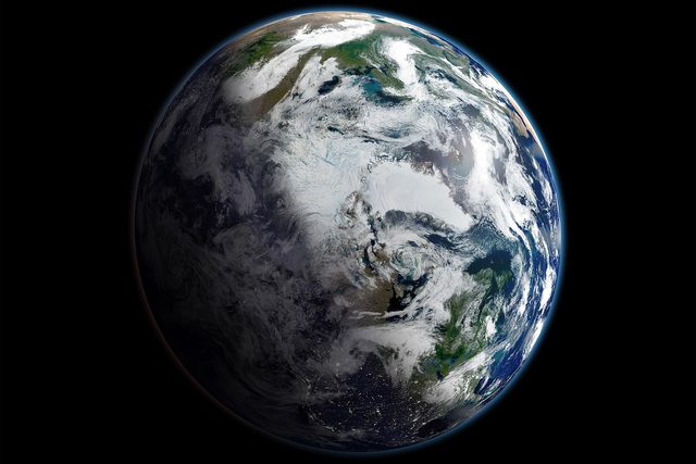 Satellietfoto van de aarde van bovenaf, met het witte ijs en de wolken rond de Noordpool.